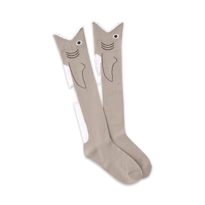 Pair of grey knee-high socks with a whimsical shark face design.  Black outlines and white accents complete the look.