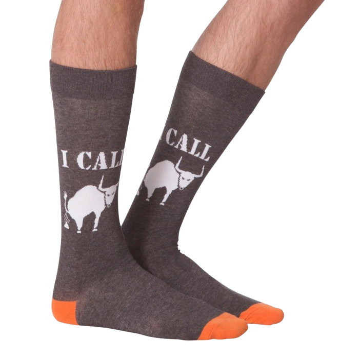 A pair of gray calf-length socks with an orange toe and heel. The socks have the words 