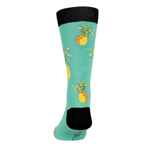 A mid-calf length sock with a green background and a pattern of pineapples. The toe and heel are black.