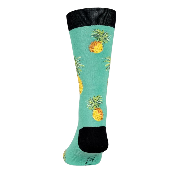 A mid-calf length sock with a green background and a pattern of pineapples. The toe and heel are black.