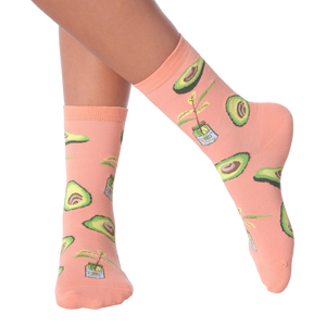 Lifestyle shot of woman's legs wearing peach avocado socks.