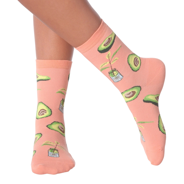 Lifestyle shot of woman's legs wearing peach avocado socks.
