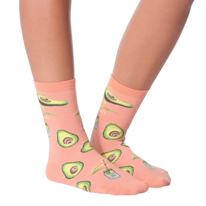 Lifestyle shot of woman's legs wearing peach avocado socks, different pose.