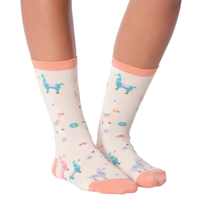 A pair of off-white socks with a colorful pattern of llamas, flowers, and birds. The socks have a pink toe, heel, and cuff.