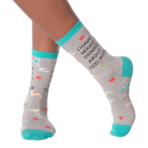 Lifestyle shot of woman's legs wearing the 'I Have Mixed Drinks About Feelings' socks, showing the fit and style on the feet.