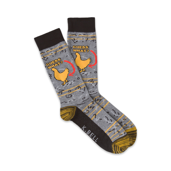 Pair of crew socks in grey, brown, and yellow.  Features a funny illustration of a chicken and the text 'Guess What?'