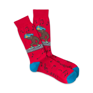 Pair of red crew socks with a cartoon Bigfoot carrying a boombox.  Musical notes and teal cuffs add to the fun, 80s-inspired design.