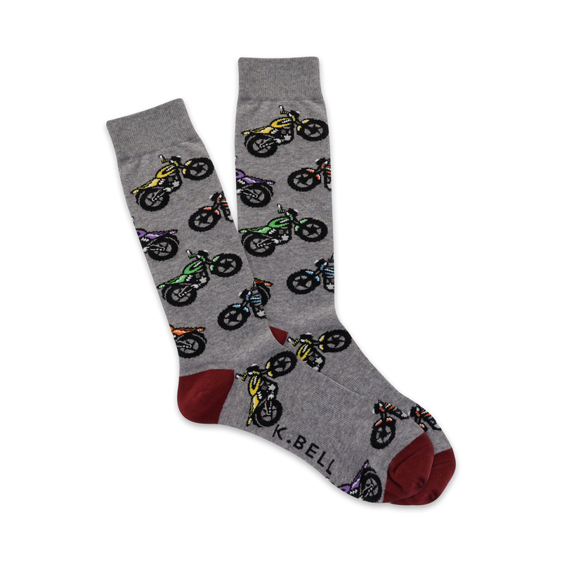 Pair of grey crew socks with a repeating pattern of multicolored motorcycles. Red and grey heel and toe.