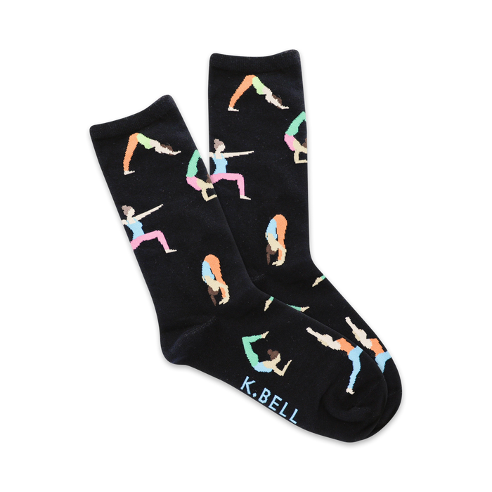 Pair of black crew socks with colorful illustrations of diverse women in various yoga poses. 'K.BELL' is subtly printed on the sole. }}