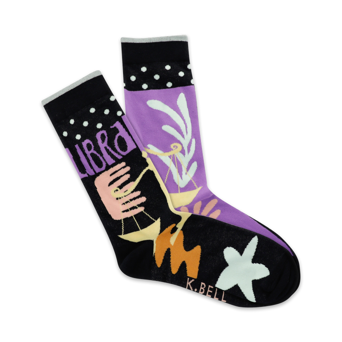 A pair of crew socks in purple and black, featuring the Libra zodiac symbol, pastel design elements, and white polka dots on the cuff. }}
