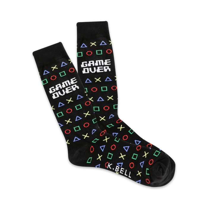 A pair of black crew socks with a playful 'Game Over' design. The socks feature colorful retro gaming symbols like squares, circles, and triangles. }}