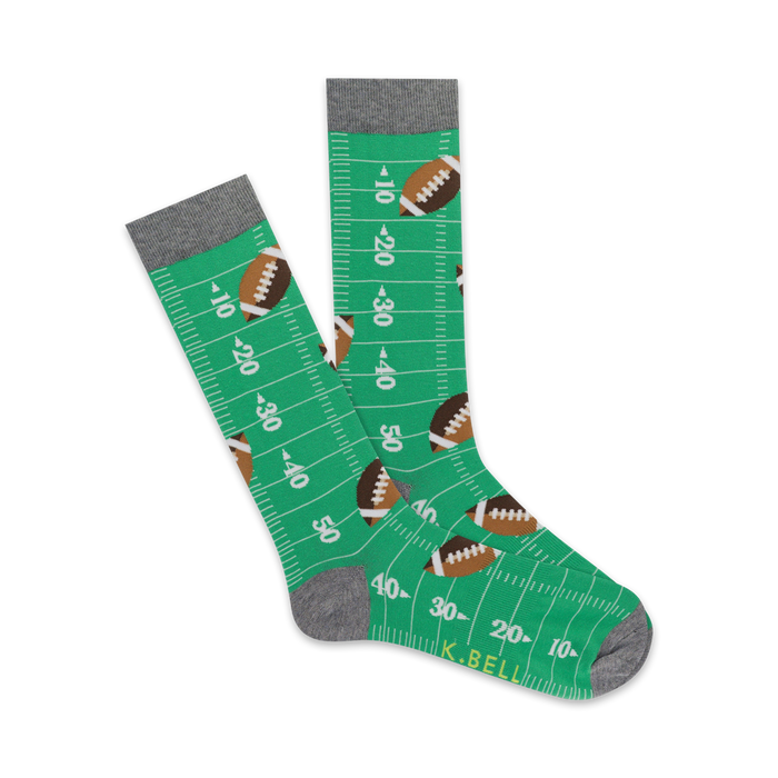 Pair of green crew socks with footballs and yard lines. Gray top trim. Fun and sporty design. }}