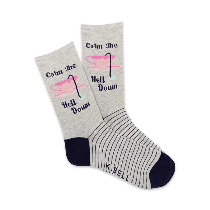 A pair of grey crew socks with thin navy stripes and a pink teacup graphic that says 'Calm the Hell Down'. }}