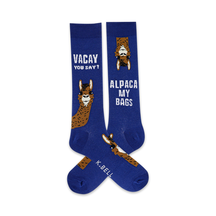 Pair of crew socks, blue with brown alpaca illustrations.  One sock says 'Vacay you say?' and the other says 'Alpaca My Bags'. }}