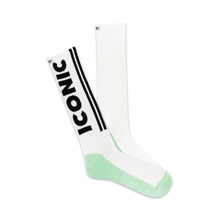 A pair of white crew socks with a black 'Iconic' logo and mint green heel and toe. }}