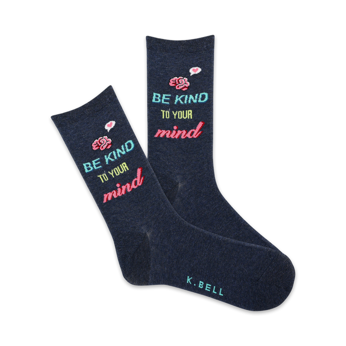 Pair of navy blue crew socks with the phrase 'Be Kind To Your Mind' in pastel colors and small flower illustrations. }}