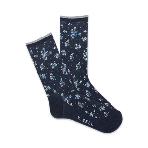Close-up view of navy blue crew socks with a tiny white floral pattern. Pink trim at the top and 'K.BELL' logo.