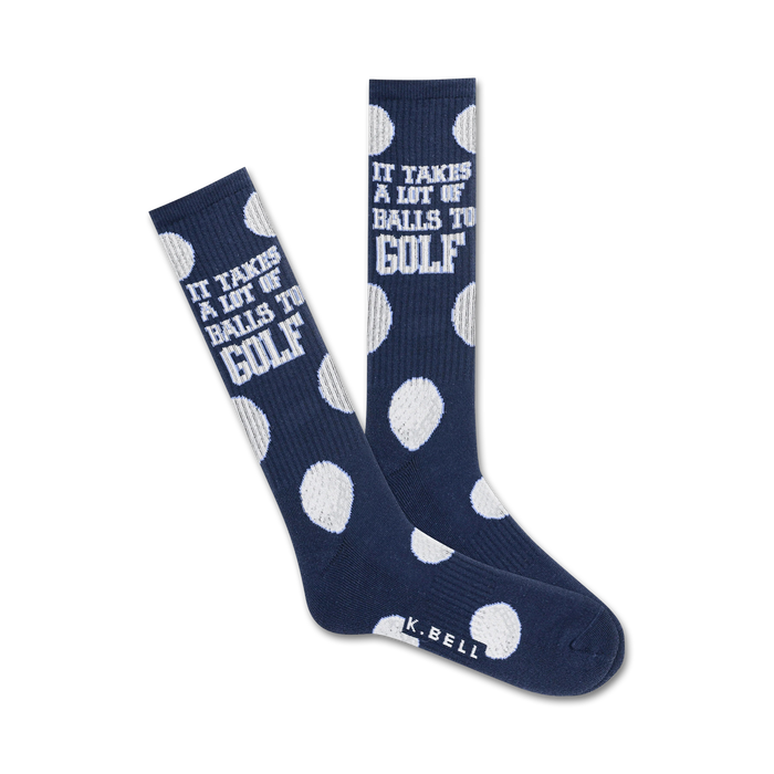 Pair of navy blue crew socks with white golf ball polka dots and the text 'It takes a lot of balls to golf!' }}