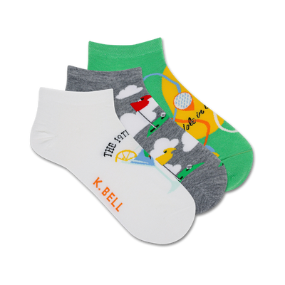 Three ankle socks; one white with golf-themed illustration, one gray with golf course, one green with golf ball. K. Bell logo.