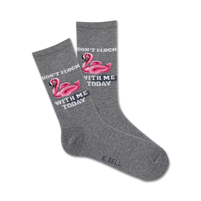 gray crew socks with pink flamingo design wearing sunglasses and floating on inner tube. text on socks reads 