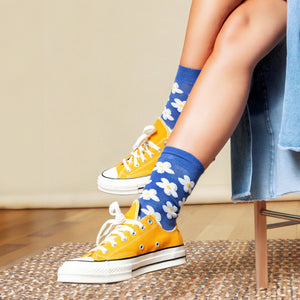 Lifestyle photo showing a person's legs wearing the Daisy Dot socks with yellow Converse sneakers.