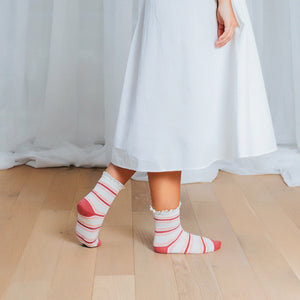 Lifestyle shot of a person wearing the dusty rose and cream striped crochet lace socks