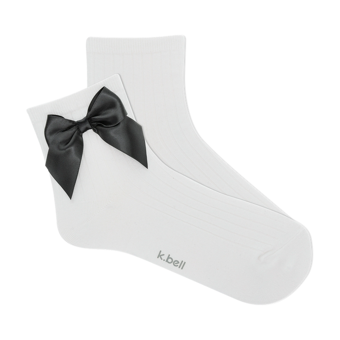 Pair of white ribbed ankle socks with a black satin bow.  The socks are shown against a black background.