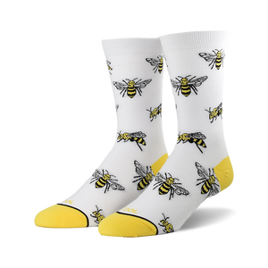 A pair of white crew socks with a repeating pattern of illustrated bees and yellow cuffs.