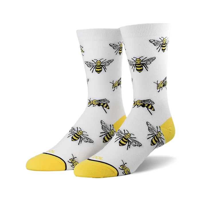 A pair of white crew socks with a repeating pattern of illustrated bees and yellow cuffs.