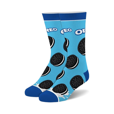 Pair of crew socks on light blue background, adorned with Oreo cookies and a milk splash at the bottom. Black and white Oreo design.