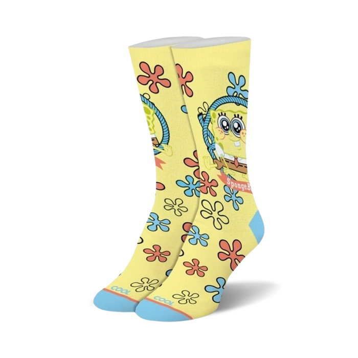 A pair of crew socks in yellow with a cartoon Spongebob Squarepants design. The socks feature blue and red flowers and light-blue cuffs. }}