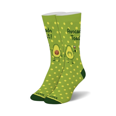 Pair of crew socks in green with yellow polka dots. Features illustrations of avocados making a toast, with one holding a glass of wine.