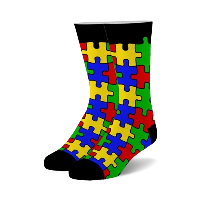 Pair of crew socks with a colorful puzzle piece design. The socks are primarily red, yellow, blue, and green, with black cuffs. }}
