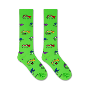 A pair of green socks with a pattern of the Teenage Mutant Ninja Turtles faces.