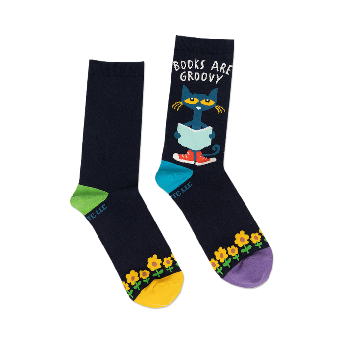 Pair of navy blue crew socks with Pete the Cat reading a book, yellow sunflowers, and colorful accents.