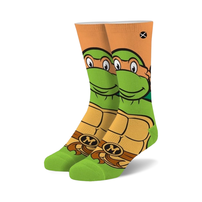 Crew socks featuring Michelangelo from TMNT. Green, orange, and brown colors.  Mikey's face and shell are prominently displayed.