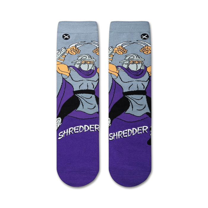 Flatlay showcasing a pair of TMNT Shredder crew socks, purple and grey.
