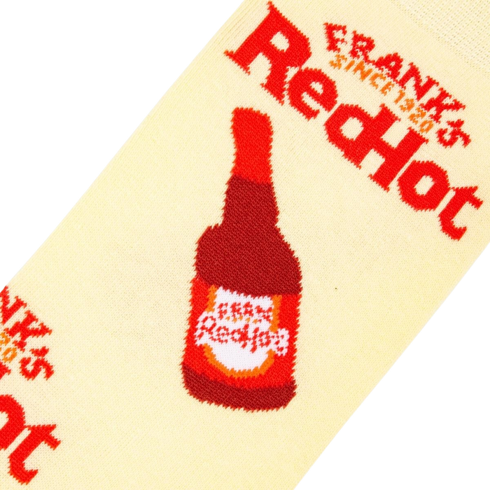 Close-up detail shot of a Frank's RedHot bottle graphic on a cream-colored sock.