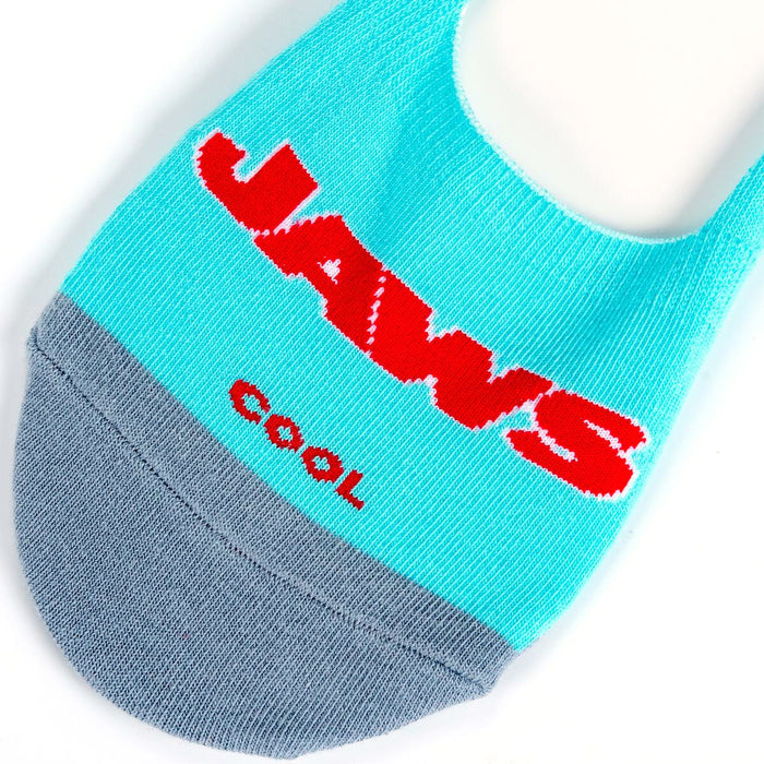 Lifestyle product shot showing a pair of 'Jaws' no-show socks laid flat, displaying both the logo and shark designs.