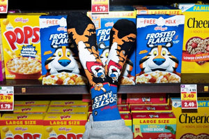 A person is wearing socks with the Frosted Flakes logo on them. The socks are blue and have the words 