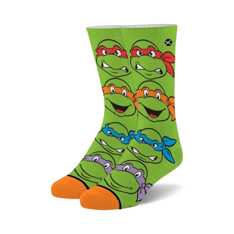 Crew socks in bright green featuring the faces of all four Teenage Mutant Ninja Turtles. Orange and purple accents around the turtle's mask.