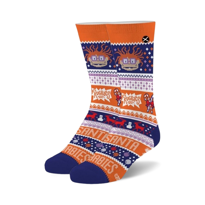 Pair of crew socks in orange, blue, and purple. Features a festive design with Chuckie Finster from Rugrats, candy canes, snowmen, and reindeer.