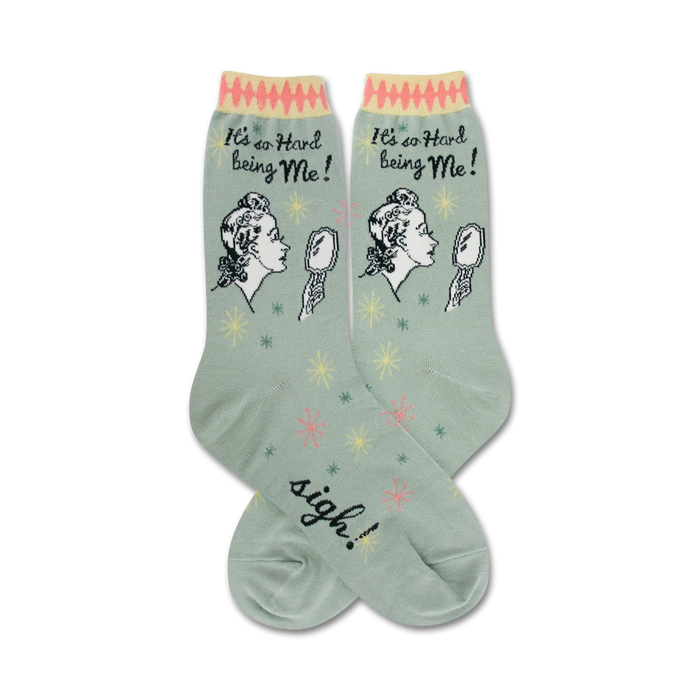 Pair of women's crew socks in sage green. Features a retro illustration of a woman looking in a mirror and the text 'It's so hard being me!' }}