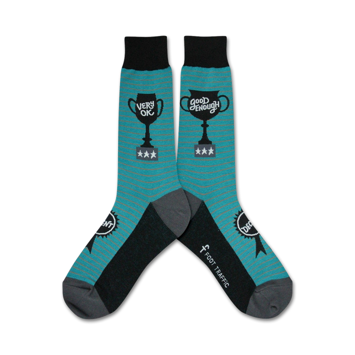 Pair of teal and black crew socks. One sock reads 'Very OK' and the other 'Good Enough', both displayed on a trophy graphic above three stars. }}