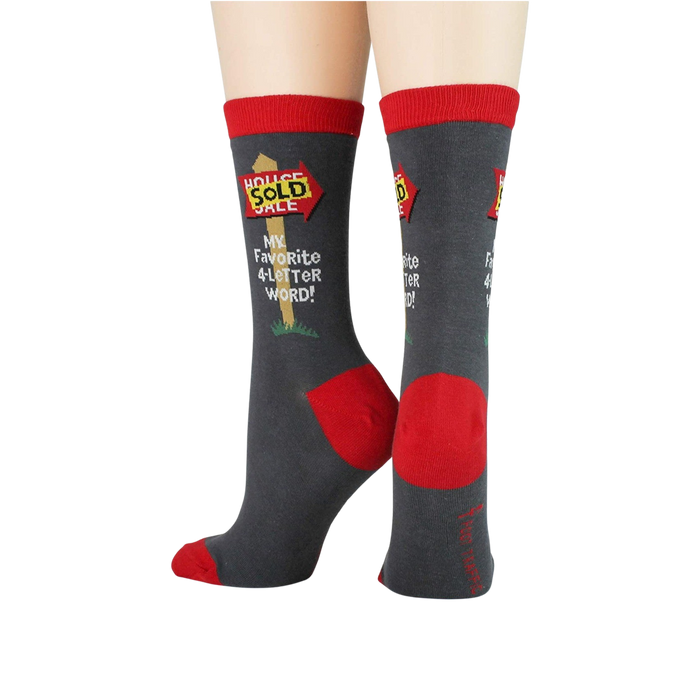 A pair of gray socks with red toes, heels, and tops. The socks have the words 