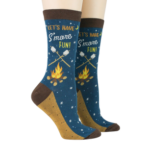 Pair of 'Let's Have S'more Fun!' socks on a model's feet against a black background.