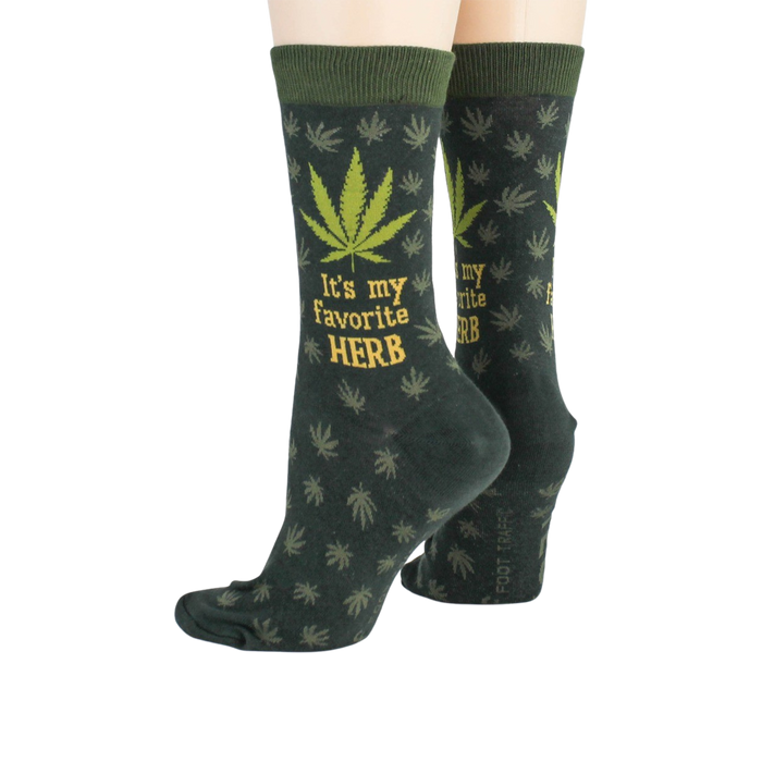 Close-up flatlay showcasing the detail of the marijuana leaf socks, highlighting the 'It's my favorite herb' text and '420' detail.