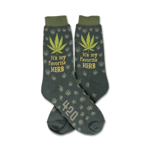 Crew socks in dark green with a repeating marijuana leaf pattern.  'It's my favorite herb' and '420' are featured on the socks.