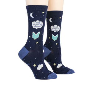 A pair of blue socks with a pattern of white stars, moons, and clouds. The socks have the words 