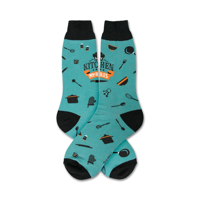 Pair of teal crew socks with black cuffs.  Features orange text 'My Kitchen My Rules' and small kitchen utensil icons.